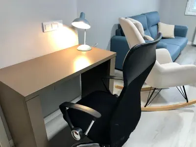 a office with a desk and a chair and a couch at Apartamento Muralla in Lugo