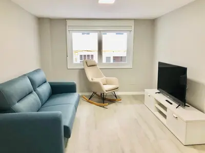 a living room with a couch and a chair and a television at Apartamento Muralla in Lugo