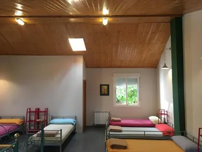 a room with four bunk beds and a wooden ceiling at Albergue de la Piedra in Villafranca del Bierzo