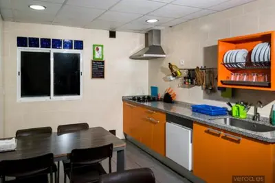 a kitchen with orange cabinets and a counter top at Albergue de la Piedra in Villafranca del Bierzo