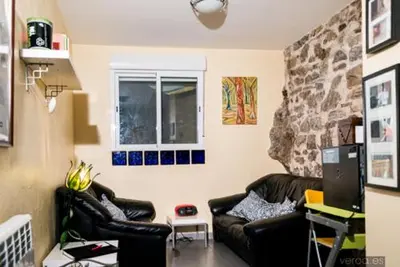 a living room with two leather couches and a window at Albergue de la Piedra in Villafranca del Bierzo
