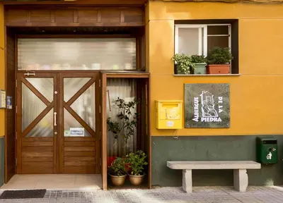 a building with a door and a bench in front of it at Albergue de la Piedra in Villafranca del Bierzo