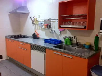 a kitchen with orange cabinets and a sink at Albergue de la Piedra in Villafranca del Bierzo
