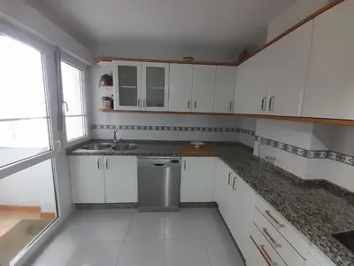 a small kitchen with white cabinets and a sink at NORAY in Ribadeo