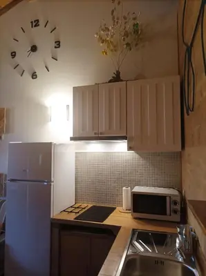 a kitchen with a refrigerator and a clock on the wall at Apartamento Da Moura in Maus de Salas