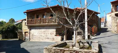 a stone house with a balcony on a street at Apartamento Da Moura in Maus de Salas