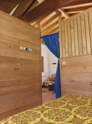 a bedroom with a bed and a wooden wall at Apartamento Da Moura in Maus de Salas