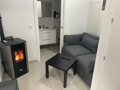 a living room with a couch and a stove at Casa Triacastela in Tríacastela