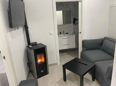 a living room with a couch and a wood burning stove at Casa Triacastela in Tríacastela
