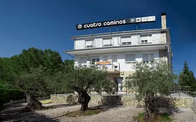 a building with a sign on the side of it at Hostal Restaurante Cuatro Caminos in Cubillos del Sil