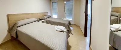 a room with three beds in a room at Hostal Restaurante Cuatro Caminos in Cubillos del Sil