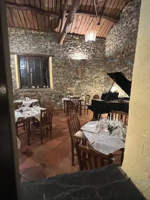 a dining room with tables and a grand piano at Hotel y Apartamentos Penarronda Playa in Castropol