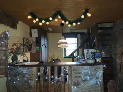 a kitchen with a bar and a chandelier at Hotel y Apartamentos Penarronda Playa in Castropol
