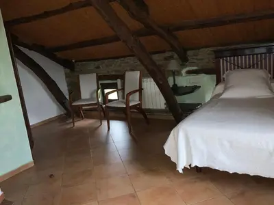 a bedroom with a bed and two chairs at Hotel y Apartamentos Penarronda Playa in Castropol