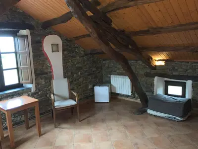 a room with a bed and a chair in a building at Hotel y Apartamentos Penarronda Playa in Castropol