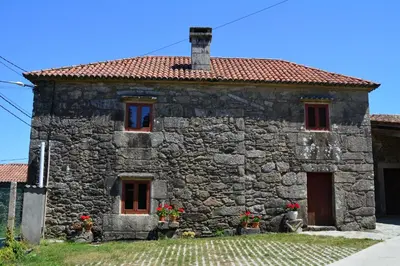 an old stone house with a red roof at CASA DO SANTO in Santiago de Compostela