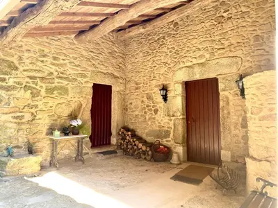 a stone building with two doors and a table at CASA DO SANTO in Santiago de Compostela