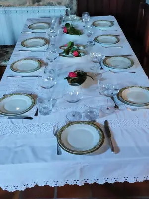 a long table with white plates and glasses on it at CASA DO SANTO in Santiago de Compostela