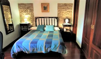a bedroom with a bed with a blue comforter at CASA DO SANTO in Santiago de Compostela