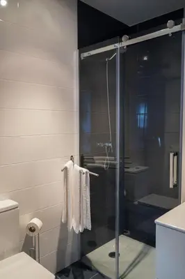 a bathroom with a glass shower stall with towels at Mar de Sada in Sada