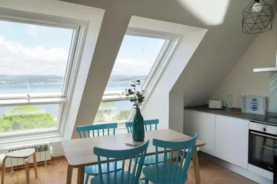 a kitchen with a table and chairs and large windows at Mar de Sada in Sada