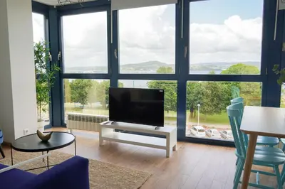 a living room with a tv and a large window at Mar de Sada in Sada