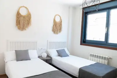a bedroom with two beds and two mirrors on the wall at Mar de Sada in Sada