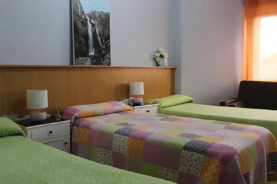 a bedroom with two beds and a couch at Albergue Turístico Silleda in Silleda