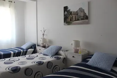 a bedroom with two beds and a picture on the wall at Albergue Turístico Silleda in Silleda