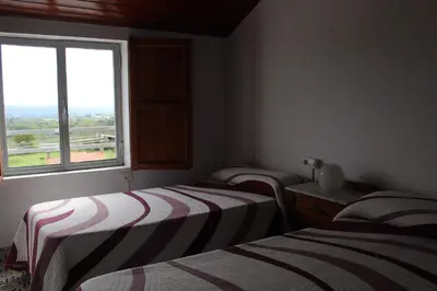 two beds in a room with a window at Albergue Turístico Silleda in Silleda