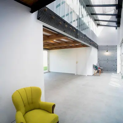 an office with a yellow chair in the middle of a room at Casa do cabo in Arzúa