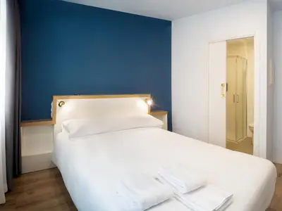 a bedroom with a white bed with a blue wall at Casa do cabo in Arzúa