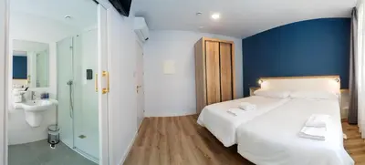 a bedroom with a large white bed and a bathroom at Casa do cabo in Arzúa