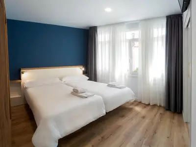 a bedroom with a white bed and a blue wall at Casa do cabo in Arzúa