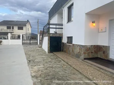 a house with a stone walkway next to a building at Villa Mauro Ribadeo Apartamento Turístico in Ribadeo