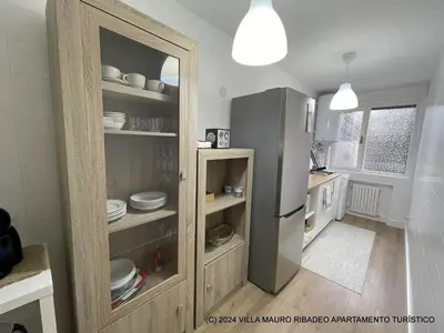 a kitchen with a refrigerator in a room at Villa Mauro Ribadeo Apartamento Turístico in Ribadeo