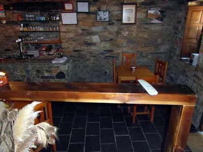 a bar with a remote control on a wooden table at Casa de Lucas in Fonfría