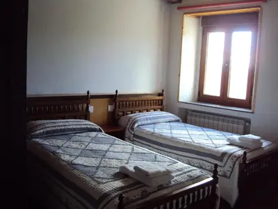three beds in a room with a window at Casa de Lucas in Fonfría