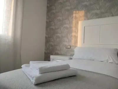 a white bed with two white towels on it at Second Home Arzúa apartamentos in Arzúa