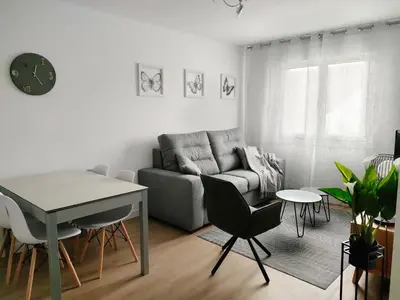 a living room with a couch and a table and chairs at Second Home Arzúa apartamentos in Arzúa