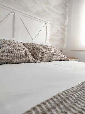 a bedroom with a white bed with a white headboard at Second Home Arzúa apartamentos in Arzúa
