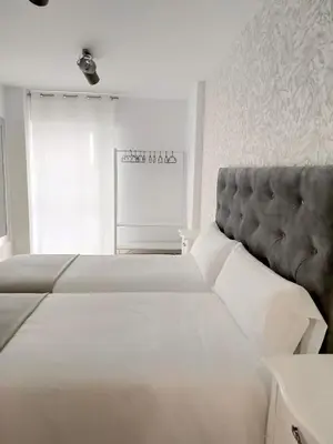 a bedroom with a large bed with a gray headboard at Second Home Arzúa apartamentos in Arzúa