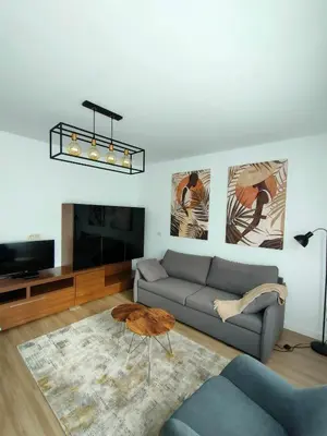 a living room with a couch and a tv at Second Home Arzúa apartamentos in Arzúa