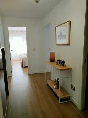 a room with a table with a vase on a shelf at Second Home Arzúa apartamentos in Arzúa