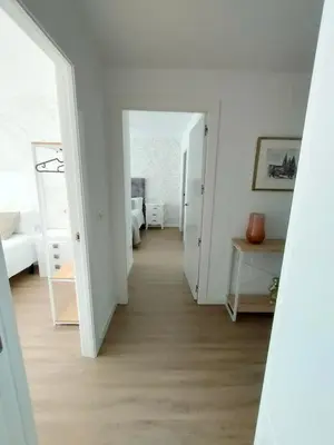 a corridor of a room with white walls and wooden floors at Second Home Arzúa apartamentos in Arzúa