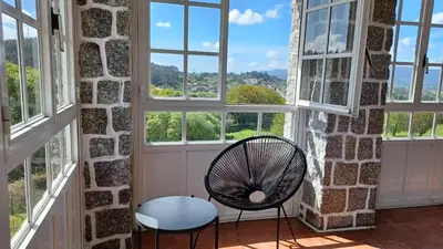 a chair in a room with windows at Hostal Boavista in Costoia
