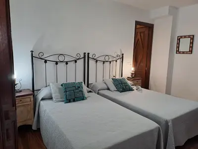 two twin beds in a bedroom with white walls at Hostal Boavista in Costoia