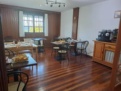a dining room with wooden floors and tables and chairs at Hostal Boavista in Costoia