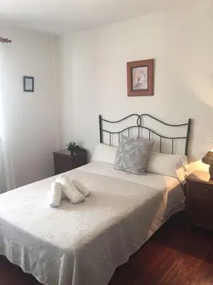 a bedroom with a bed with a white bedspread at Hostal Boavista in Costoia