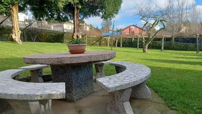 a stone table and benches with a potted plant on it at Hostal Boavista in Costoia